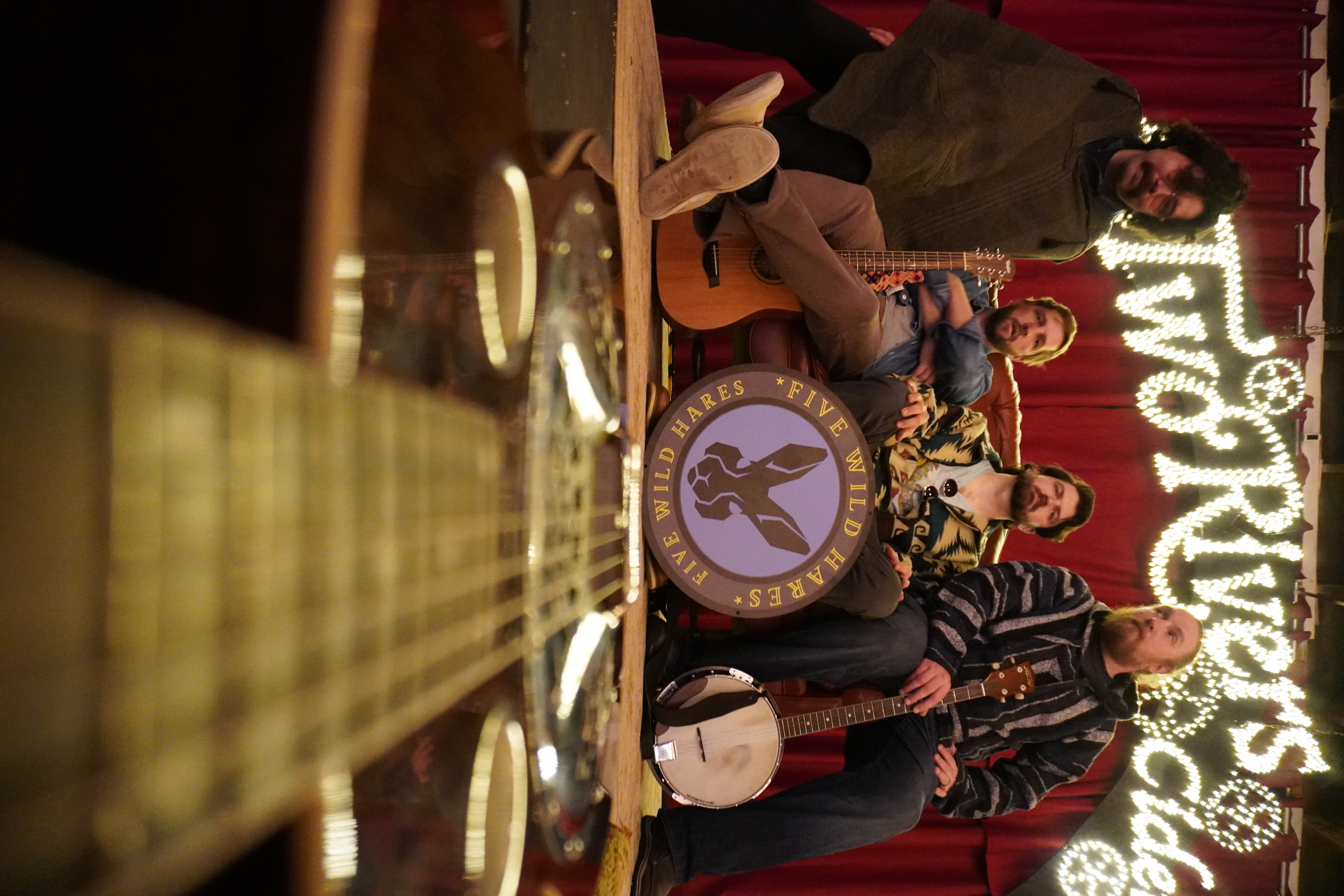 Artistic Photo of the 4 piece band from the angle of a guitar